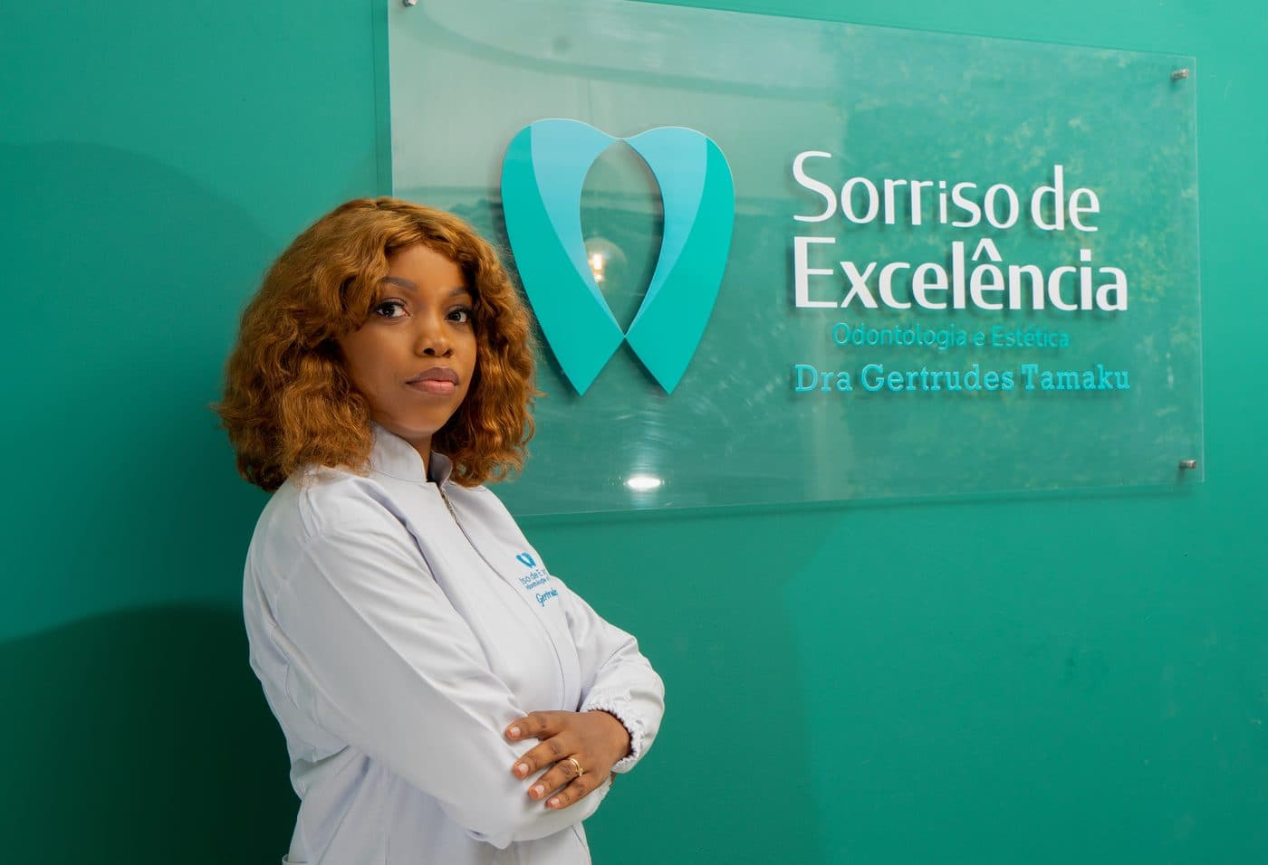Dra. Gertrudes Tamaku junto ao painel da clínica